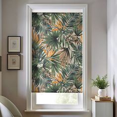 a window with a green and yellow leaf pattern on the blind in front of it