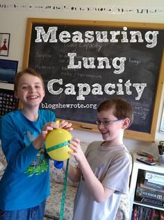 two young boys standing next to each other in front of a blackboard with the words measuring lung capacity