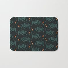 an orange and green pattern on black bath mat