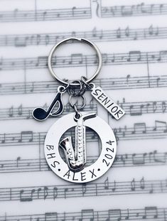 a keychain with music notes and musical notations in the background that says, senior high school aleex