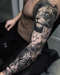 a man's arm with tattoos on it and two lions in the middle of his arm