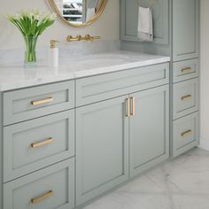 a bathroom with marble counter tops and gold accents on the mirror over the vanity area