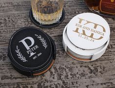 personalized coasters with monogrammed initials and names sit on a table