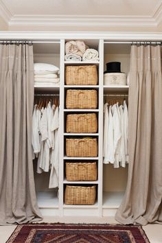 an open closet with clothes and linens in baskets on the bottom shelf next to curtains