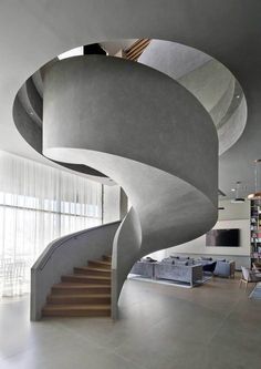 a spiral staircase in the middle of a living room with white walls and flooring