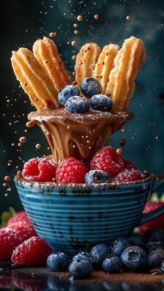 blueberries, raspberries and other berries are falling into a bowl with chocolate