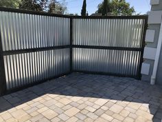 an open gate with brick pavers in front of it