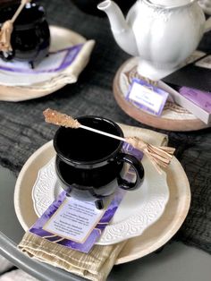 there is a cup and saucer on the table with tea bags in front of it