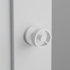 a close up of a door handle on a white door with a circular object in the center