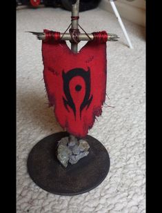 a red and black object sitting on top of a white floor next to a pile of rocks