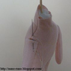 a pink stuffed animal holding an electric toothbrush in it's mouth and thread