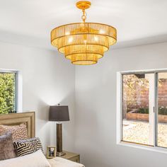 a bed room with a neatly made bed and a chandelier hanging from the ceiling