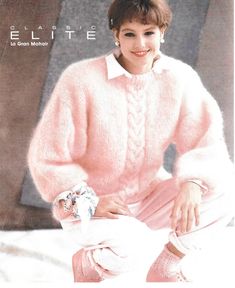 a woman in pink sweater and pants sitting on a bed