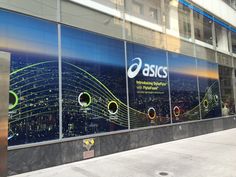 an advertisement on the side of a building for asics