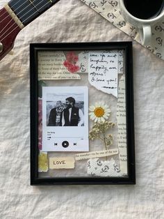 a guitar, cup of coffee and an album on a white tablecloth with flowers