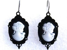 "Goth Cameo Earrings, Victorian Cameo Earrings, Black Cameo Earrings Goth inspired Victorian cameo earrings feature a white Victorian woman against a black background and set in an antiqued black frame. Hangs from an antiqued sterling silver ear wire. Length: 2 1/8 inches Coordinating necklace available here: https://www.etsy.com/listing/232060836/ Arrives with a Marty White card in a lovely decorative bag and bubble wrap packaging. Brides - Please convo me if you need additional necklaces or ea Victorian Black Earrings For Party, Gothic Black Cameo Jewelry, Gothic Drop Earrings, Black Cameo, Earrings Goth, Victorian Cameo, Wrap Packaging, White Victorian, Bubble Wrap Packaging