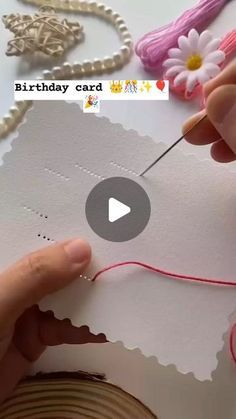 someone is making a birthday card with thread