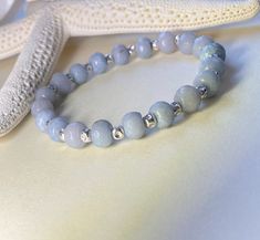 *Genuine Angelite stone bracelet, Gemstone bracelet, Angelita stone, Angelite jewelry, Gemstone and silver, Blue bracelet, Aquarius birthstone  *Angelite stones are 8X6mm faceted rondells.  *Top quality stretch cord is doubled to ensure durability and stretches to fit most any wrist comfortably from 6.5 to 8.5 inches.  *This classically designed bracelet from the Coastal Bead Treasures Collection is made with sterling silver plated spacer beads and amazing genuine Angelite gems from Peru.  *Angelite is known as the angel stone.  The stones are soft in color, a calming periwinkle pastel blue.  It occasionally has brown inclusions.  *As with all fine jewelry you should remove your Angelite bracelet before swimming or bathing. Silver Bracelets With Amazonite And Natural Stones, Silver Amazonite Bracelet As Gift, Silver Amazonite Bracelet For Gift, Adjustable Silver Stretch Bracelet With Gemstone, Angelite Jewelry, Angelite Bracelet, Aquarius Birthstone, Bracelet Gemstone, Initial Bracelet