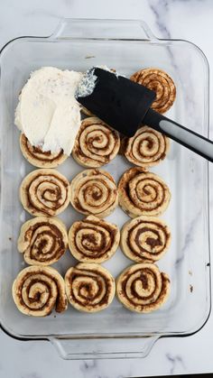 cinnamon rolls with cream cheese in a glass baking dish