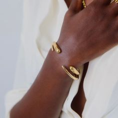 Modern and minimalist, this sculptural Delicate Dash Cuff Bracelet features a gradient, open-ended shape - a truly timeless treasure. Wear for a simple yet stunning statement. Hand-cast in recycled brass by artisans in Kenya using traditional techniques. Handcrafted in recycled brass by artisans in Kenya. Gold products are 24k gold plated brass and match our brass style in color and tone. Silver products are brass with a chrome plating. Your purchase promotes artisan innovation + entrepreneurshi Baddie Vibes, Gold Bracelet Cuff, Sugar Cane, Ethical Jewelry, Jewelry Lookbook, Open Ended, Sustainable Jewelry, Women Artisans, Timeless Treasures