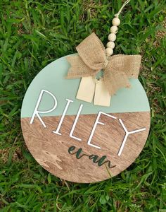 a wooden sign that says riley lawn with a bow hanging from it's side