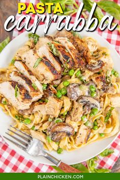 pasta with chicken, mushrooms and peas on a white plate next to a red checkered tablecloth