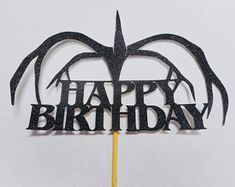 a happy birthday cake topper on a stick with the words happy birthday written in black