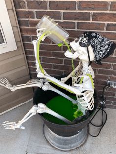 a halloween decoration made out of skeleton bones and green liquid in a bucket on the front porch