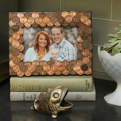 a photo frame made out of penny coins sitting on top of books