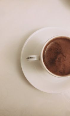 a cup of hot chocolate sitting on top of a white saucer