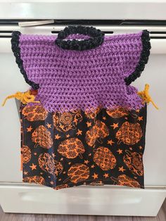 two crocheted bags sitting on top of an oven