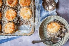 a casserole dish with biscuits and mushrooms in it next to a bowl of mashed potatoes