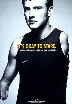 a man wearing a black tank top with the words it's okay to stare