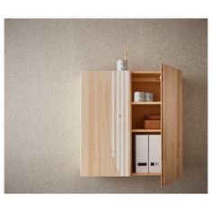 a wooden cabinet with two doors and some papers on it's shelf next to a wall