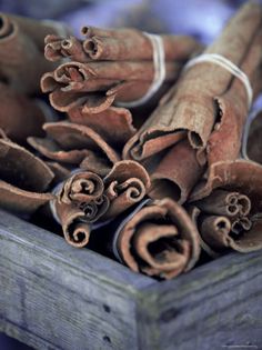 cinnamon sticks are in a wooden box on top of some other things that are brown