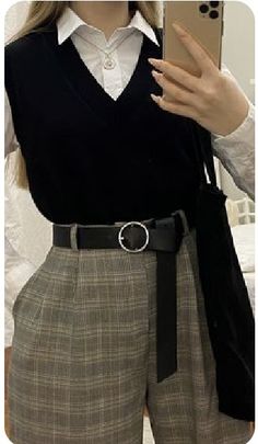 a woman is taking a selfie with her cell phone wearing a skirt and sweater