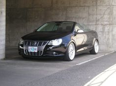 a black car parked in front of a parking garage