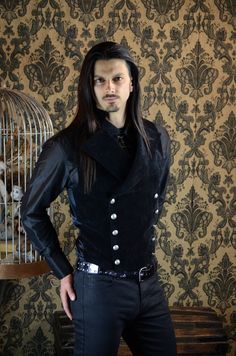 "An elegant double breasted vest for formal occasions. A fitted vest made in rich black velvet fabric with a stand up top collar and wide sweeping lapels. Fastens on the inside with a sturdy button and buttons on the outside with five antiqued metal buttons. The vest back and inside lining is made from rich black satin. Comes in sizes small-XXXL. Wonderful! Measurements: Small: Chest 39\" Stomach 36\" Waist 34\" Medium: Chest 42\" Stomach 38\" Waist 36\" Large: Chest 44\" Stomach 42\" Waist 40\" Mens Goth Formal Wear, Gothic Wedding Outfit Male, Fitted Gothic Vest For Winter, Black Elegant Vest For Costume, Elegant Black Vest For Costume, Elegant Black Vest For Costume Party, Gothic Vest With Buttons For Fall, Party Vest With Buttons In Black, Steampunk Black Vest For Fall