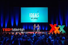 two men shaking hands on stage in front of an audience at ted mileigh