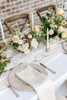 the table is set with flowers and candles