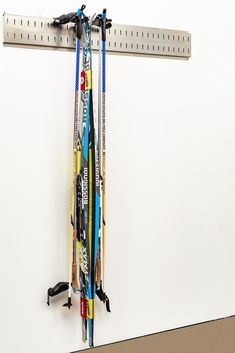 there are many skis hanging on the wall next to a rack with ski poles