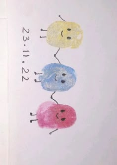 a drawing of three different colored faces on a white paper with numbers and words written below it