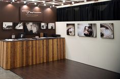 a wooden counter sitting in front of a wall with pictures on it