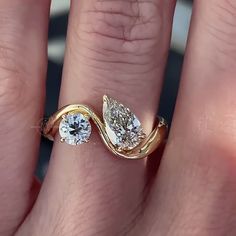 a woman's hand with a gold ring and two diamond rings on her fingers