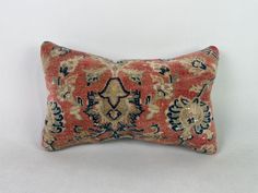 an orange and blue decorative pillow on a white background