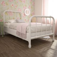 a white bed sitting on top of a wooden floor