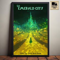 the poster for emerald city is displayed in front of a wooden table with a black frame