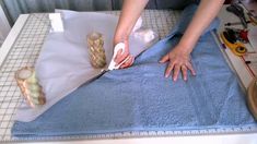 a woman is cutting fabric with scissors on a sewing machine and some other crafting supplies