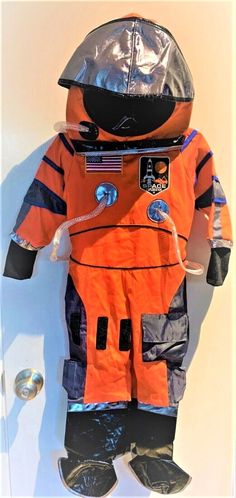 an orange astronaut suit is hanging on the wall