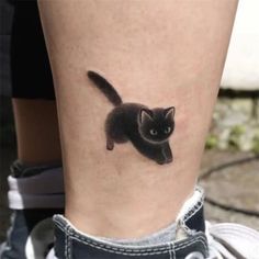 a small black cat tattoo on the right side of the leg, it looks like an animal